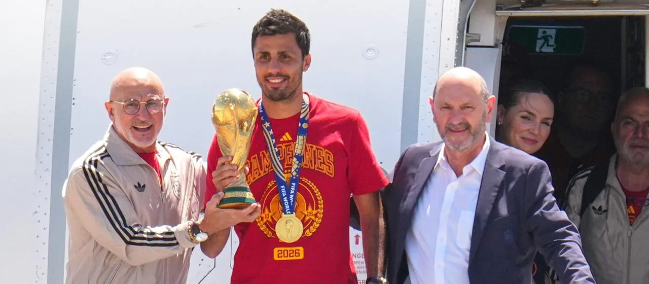 Spaniens Rodri mit dem WM-Pokal, links daneben Trainer de la Fuente